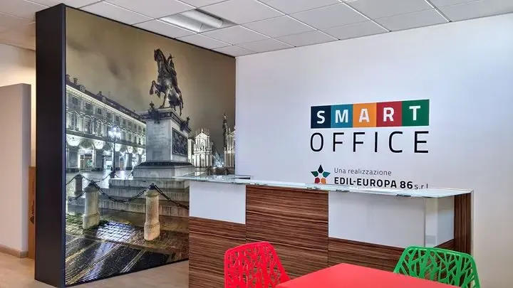 Reception aziendale con fotografia di Torino a parete e logo Smart Office