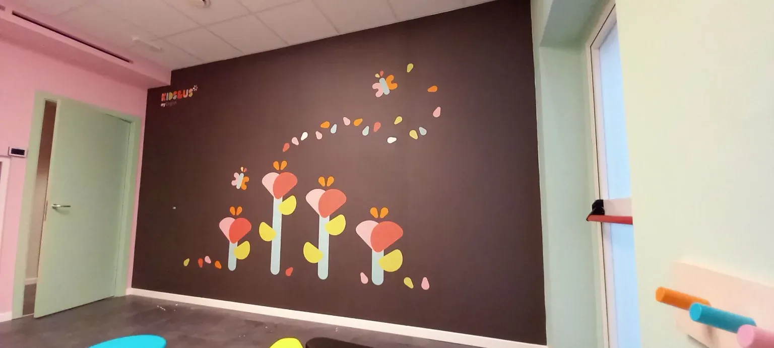 Decorazione murale floreale con frase motivazionale negli spazi Kids&Us