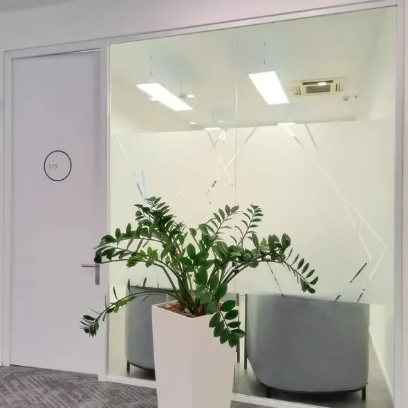 Sala riunioni schermata da una fascia satinata con intagli geometrici